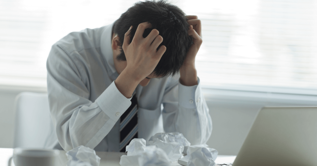 トラブルに頭を抱えて悩む男性